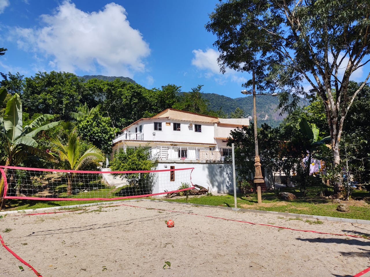 Quadra de vôlei e futebol do sítio, cercada de vegetação